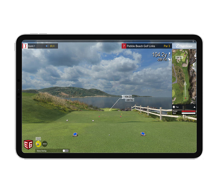 Tablet showing golf simulator view of Pebble Beach course with distance readout, FlightScope Mevo Plus launch monitor in use