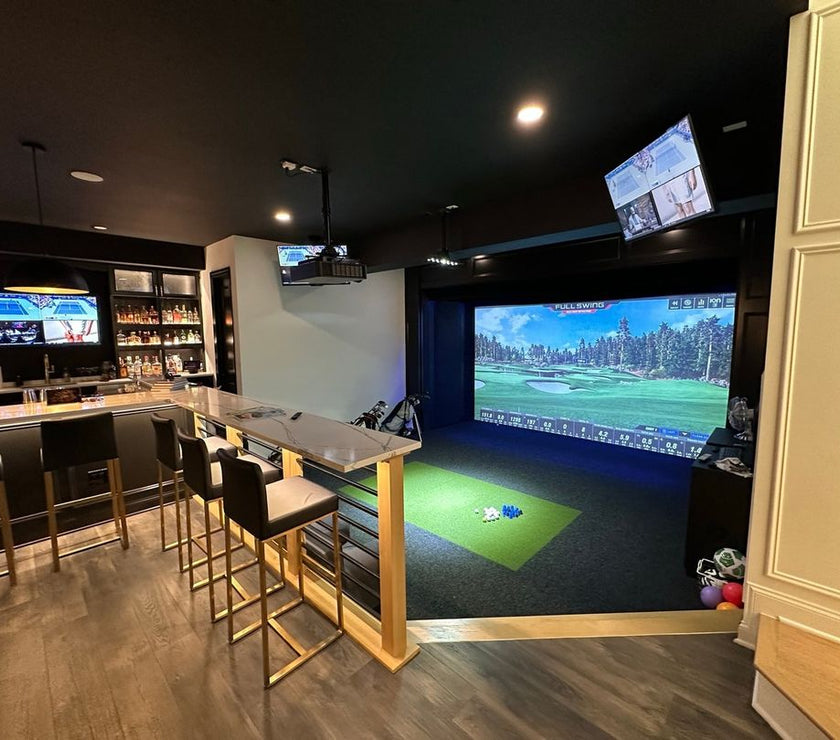 Full Swing Golf home golf simulator package in luxury basement with large projection screen hitting mat and bar seating