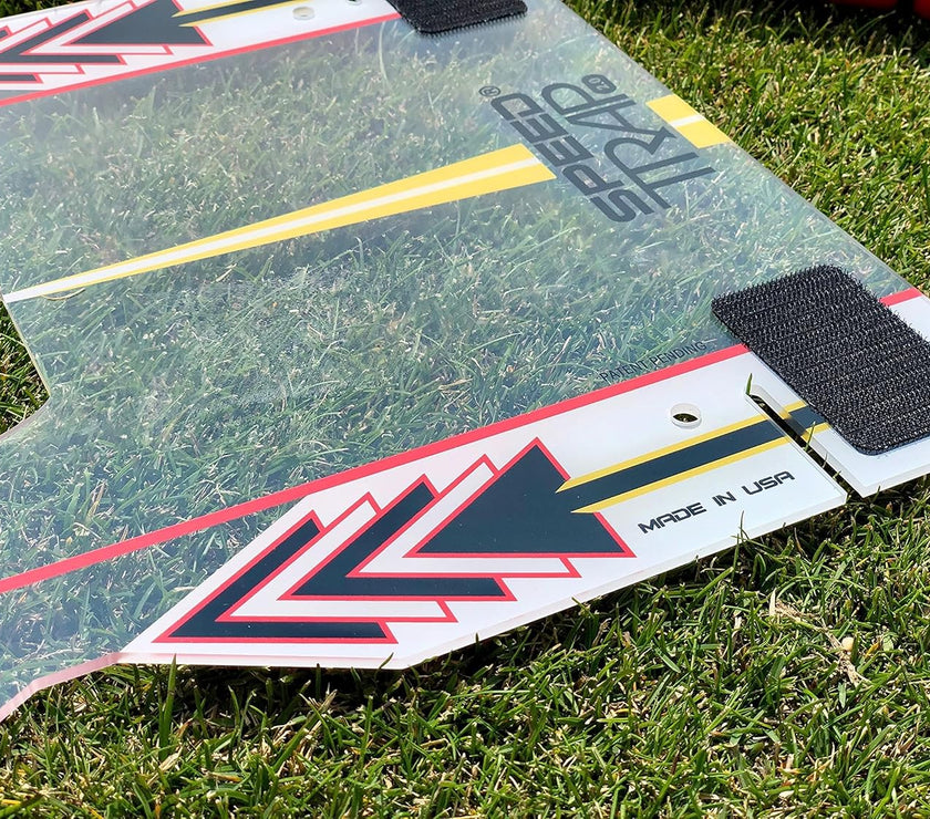Clear plastic golf alignment board with arrows and velcro on grass Speed Trap swing trainer