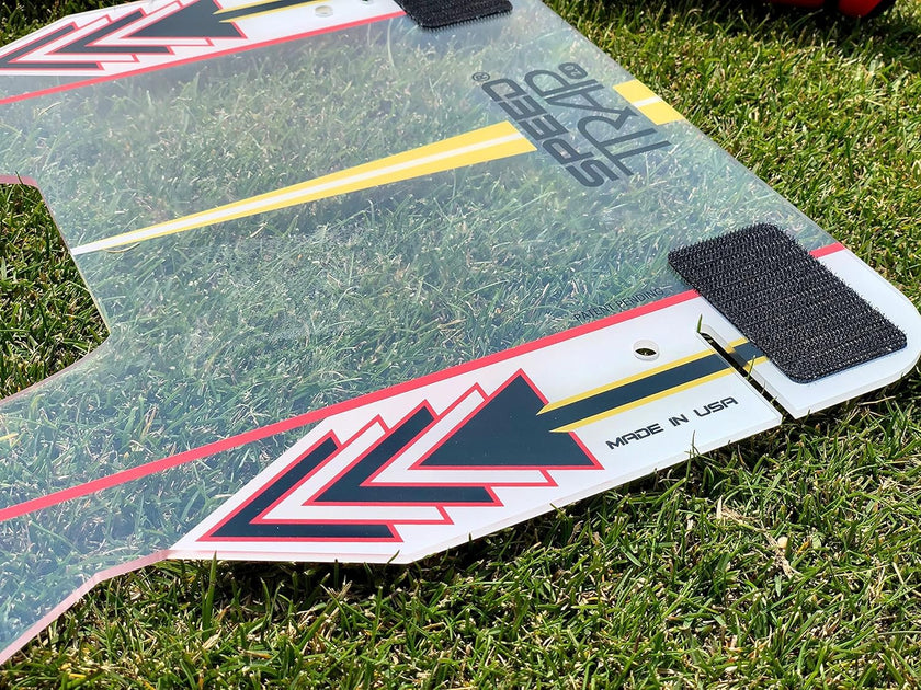Clear plastic golf alignment board with arrows and velcro on grass Speed Trap swing trainer