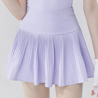 Light purple women's golf polo shirt paired with a pleated skirt for a stylish golf outfit