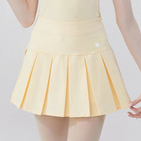 Stylish yellow women's golf polo shirt paired with a pleated golf skirt for a fashionable look on the course